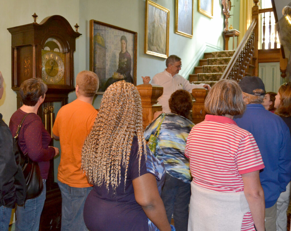 a man standing on stairs talking to a group of people